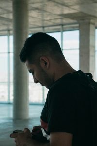 Man checking phone alone — anxious attachment triggers