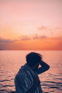 person standing at sunset over the ocean representing healing anxious attachment