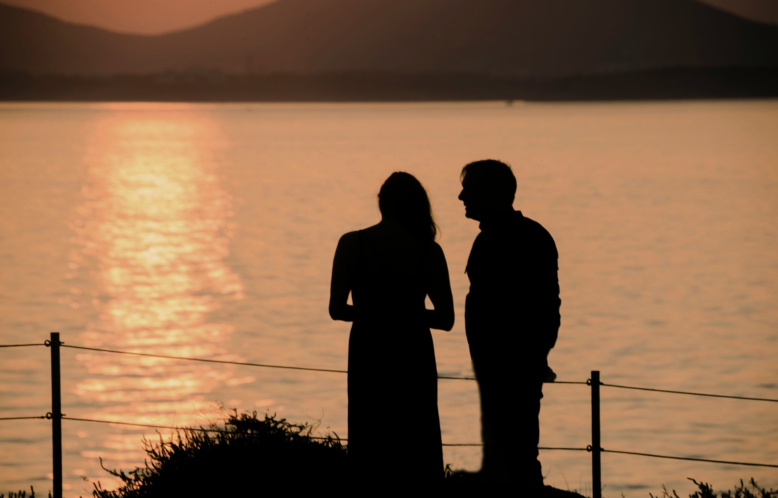 Couple standing in silence at sunset — avoidant attachment and conflict