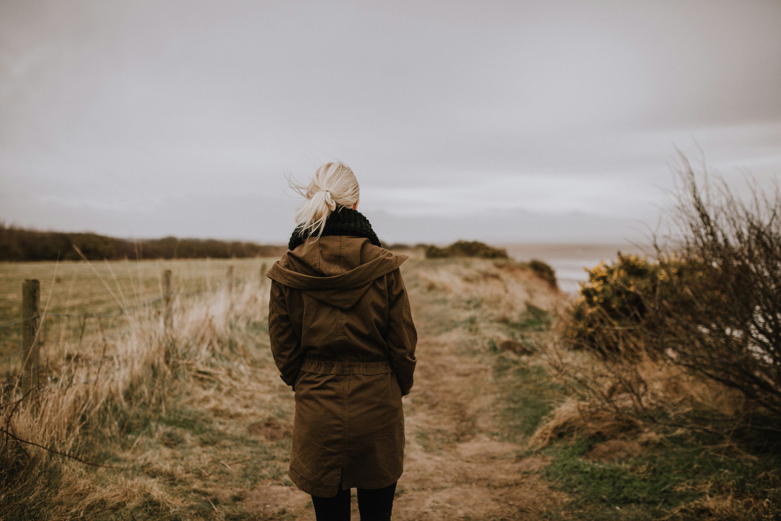 woman standing alone on a windy path representing the healing journey from fearful avoidant attachment