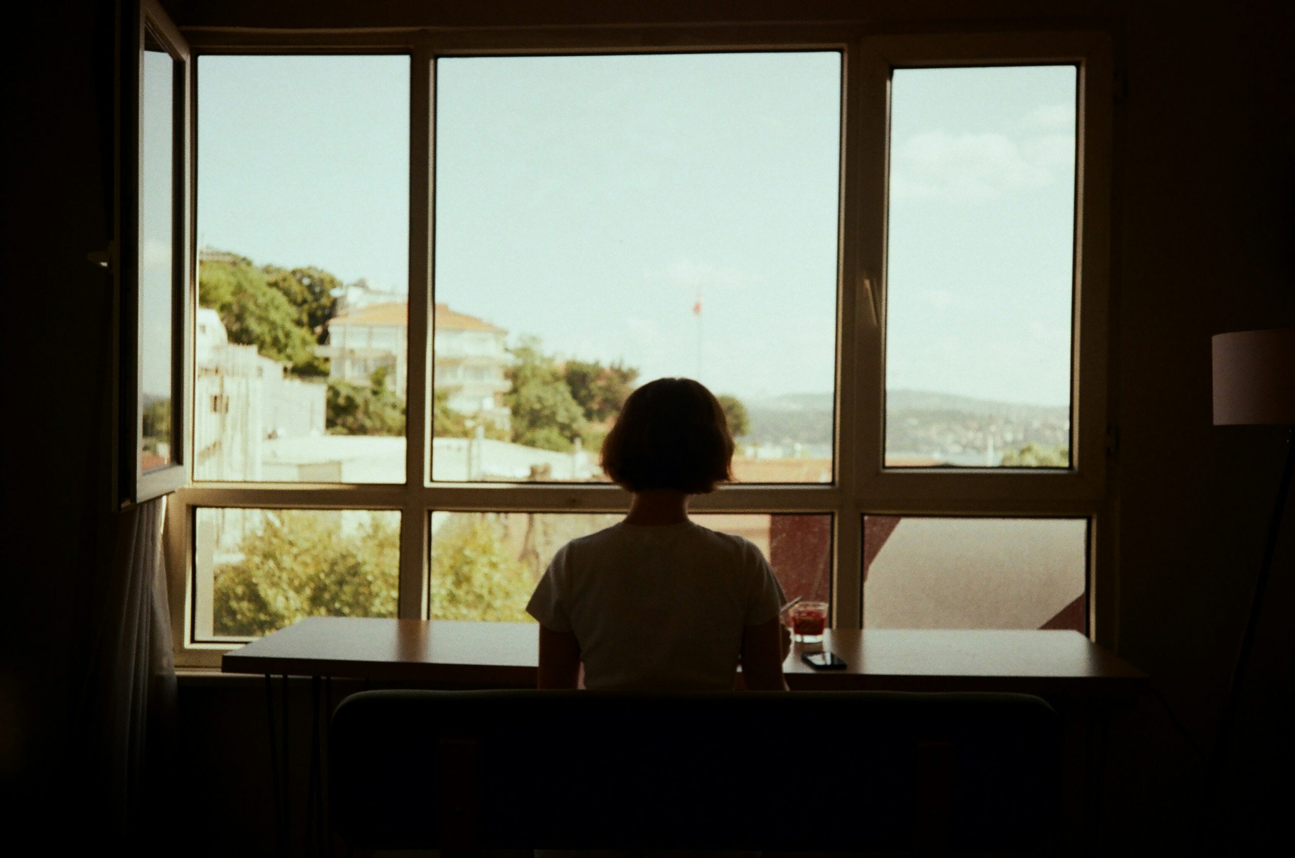 Woman alone at window reflecting on love bombing and anxious attachment patterns